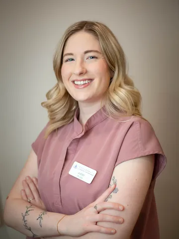 a woman with arms crossed smiling