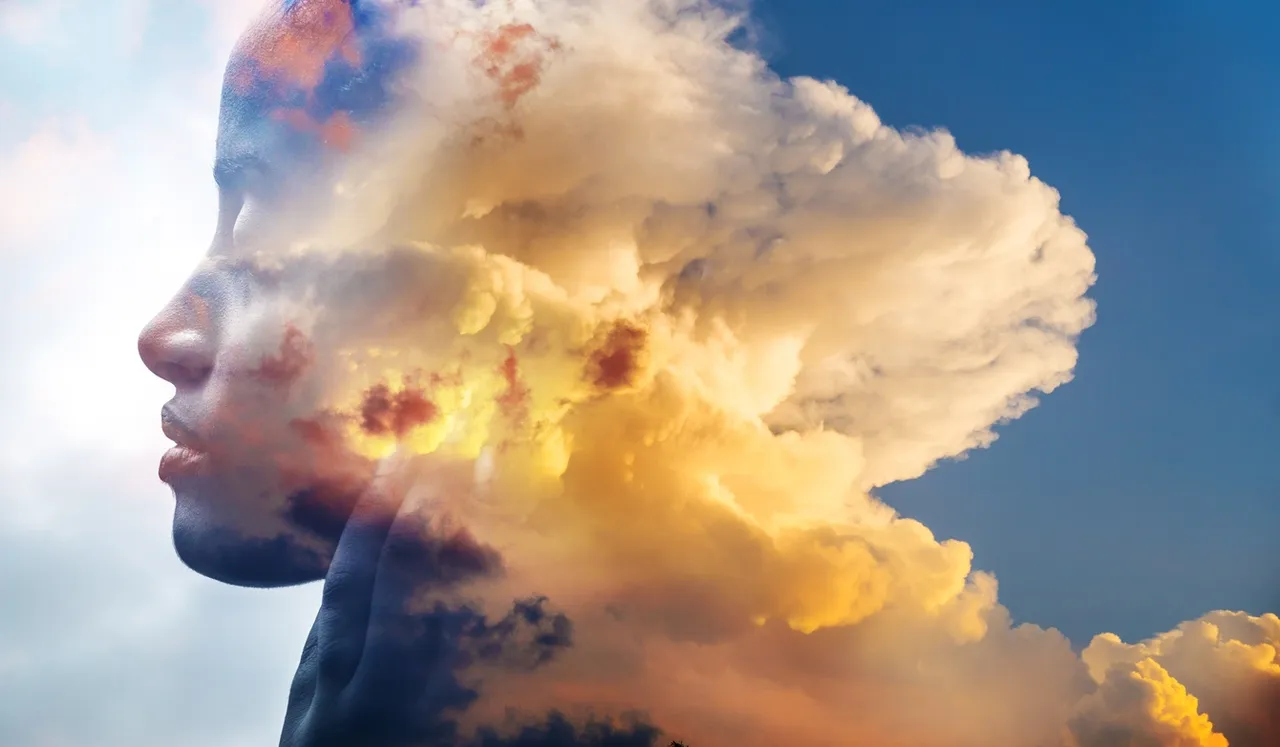 a person's face with clouds
