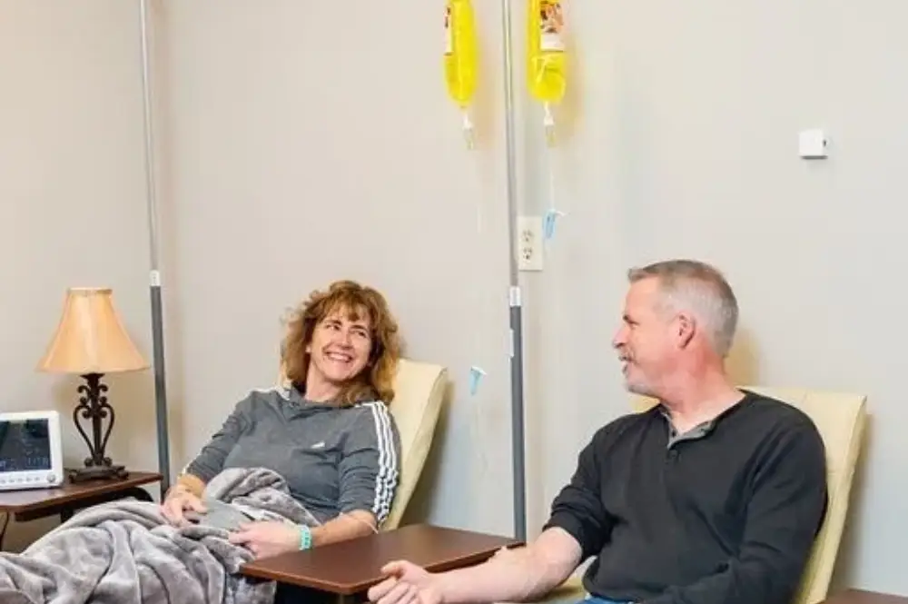 a man and woman sitting in a hospital chair