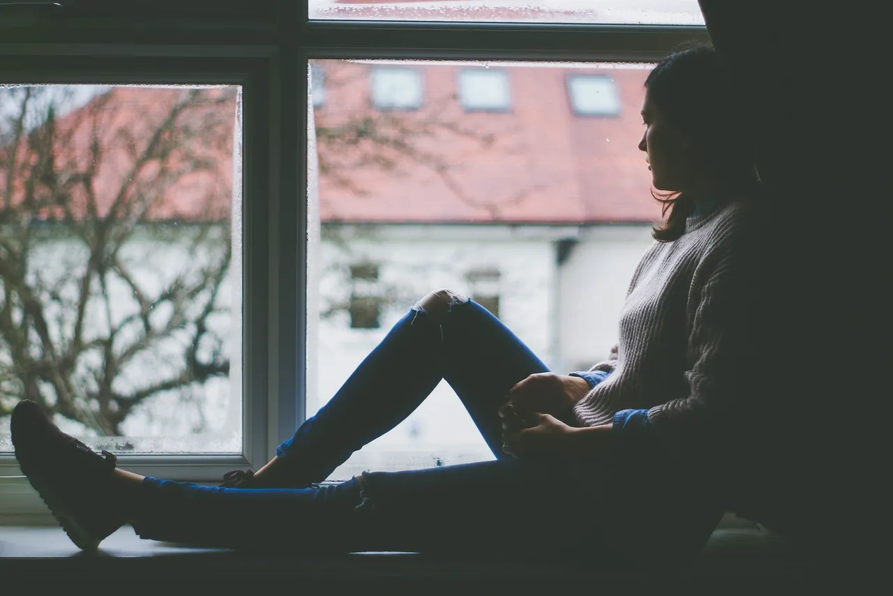 a woman sitting on a window sill