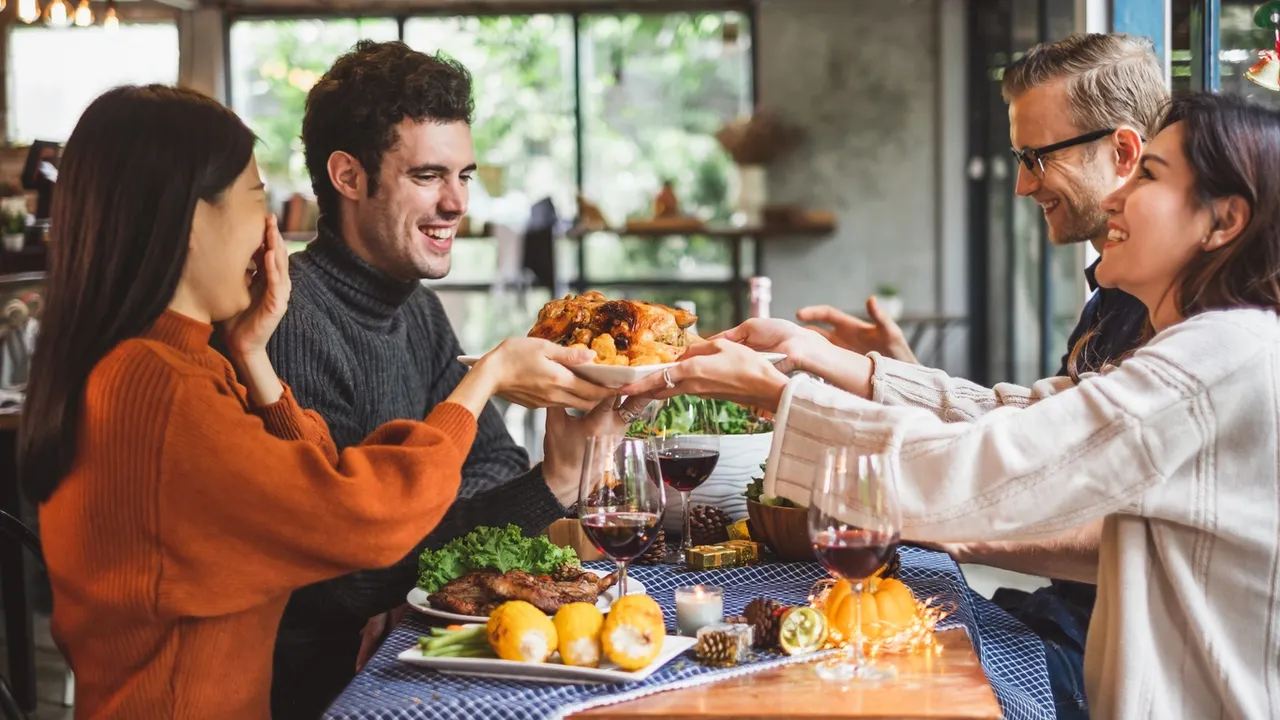 a group of people sitting at a table with food and drinks
