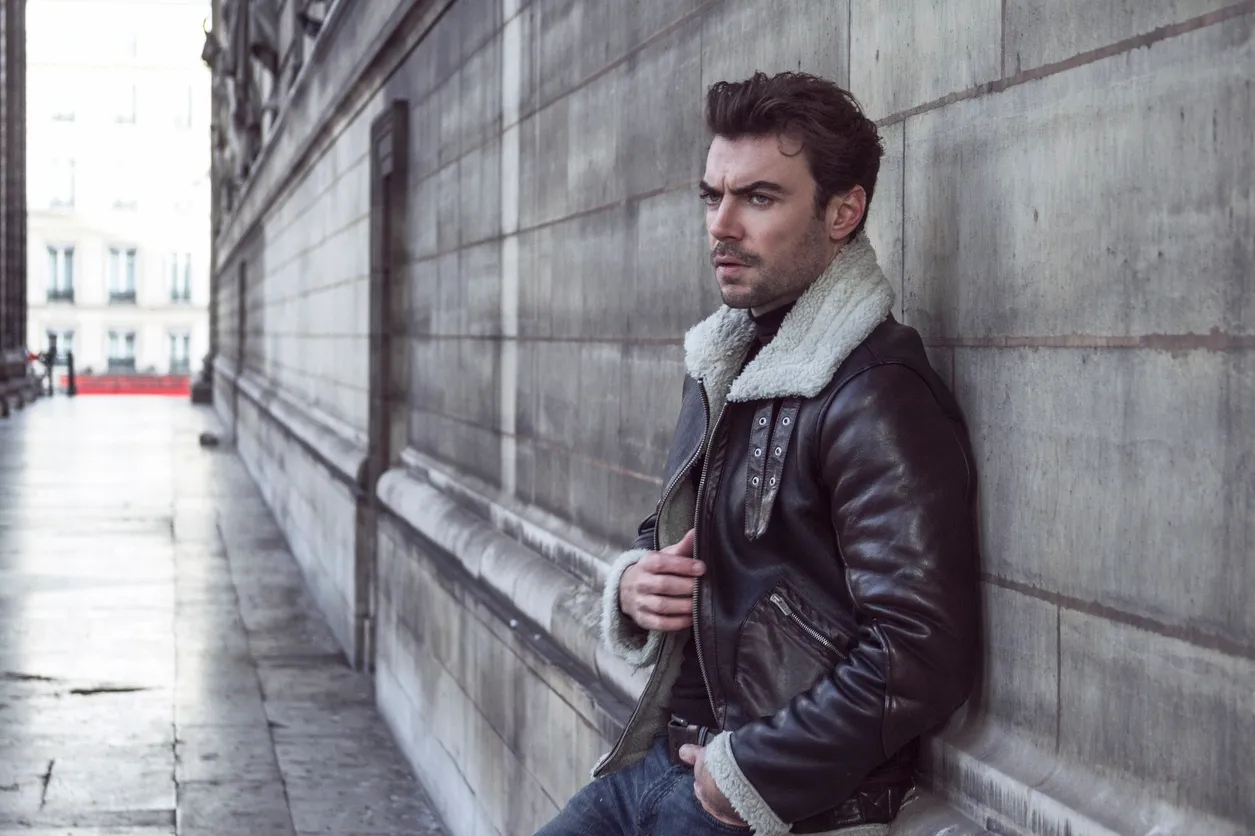 a man leaning against a wall