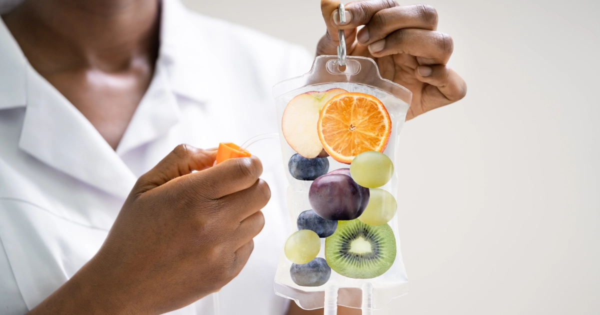 A person in a lab coat holding an IV bag filled with fresh fruit, representing IV Therapy in Olympia, WA.
