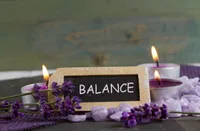 a sign with lit candles and purple flowers - five ways to holistically ease your mood disorder symptoms