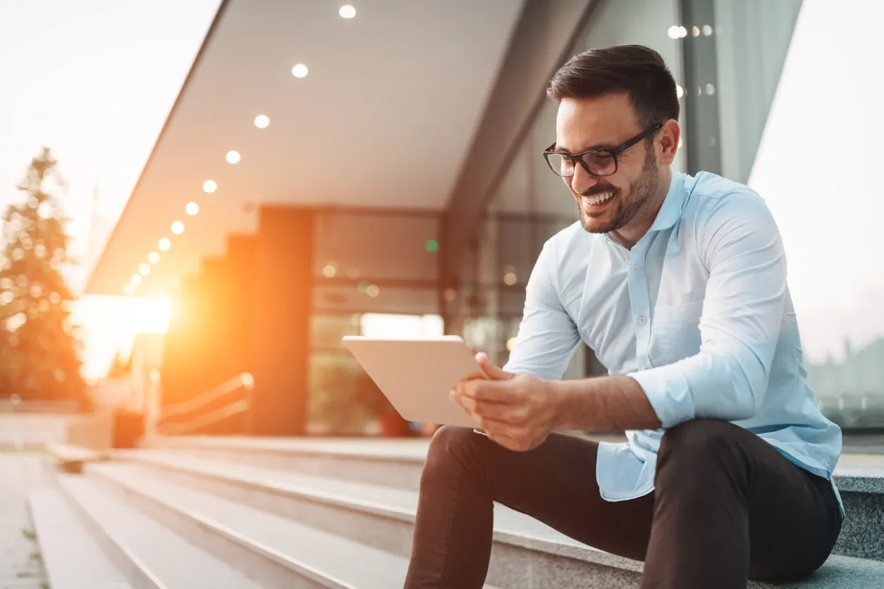 a man sitting on steps with his tablet - keep your mind healthy and balanced with social distancing