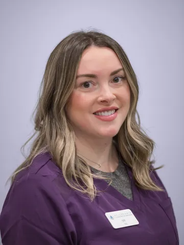 a woman in purple scrubs - lvy