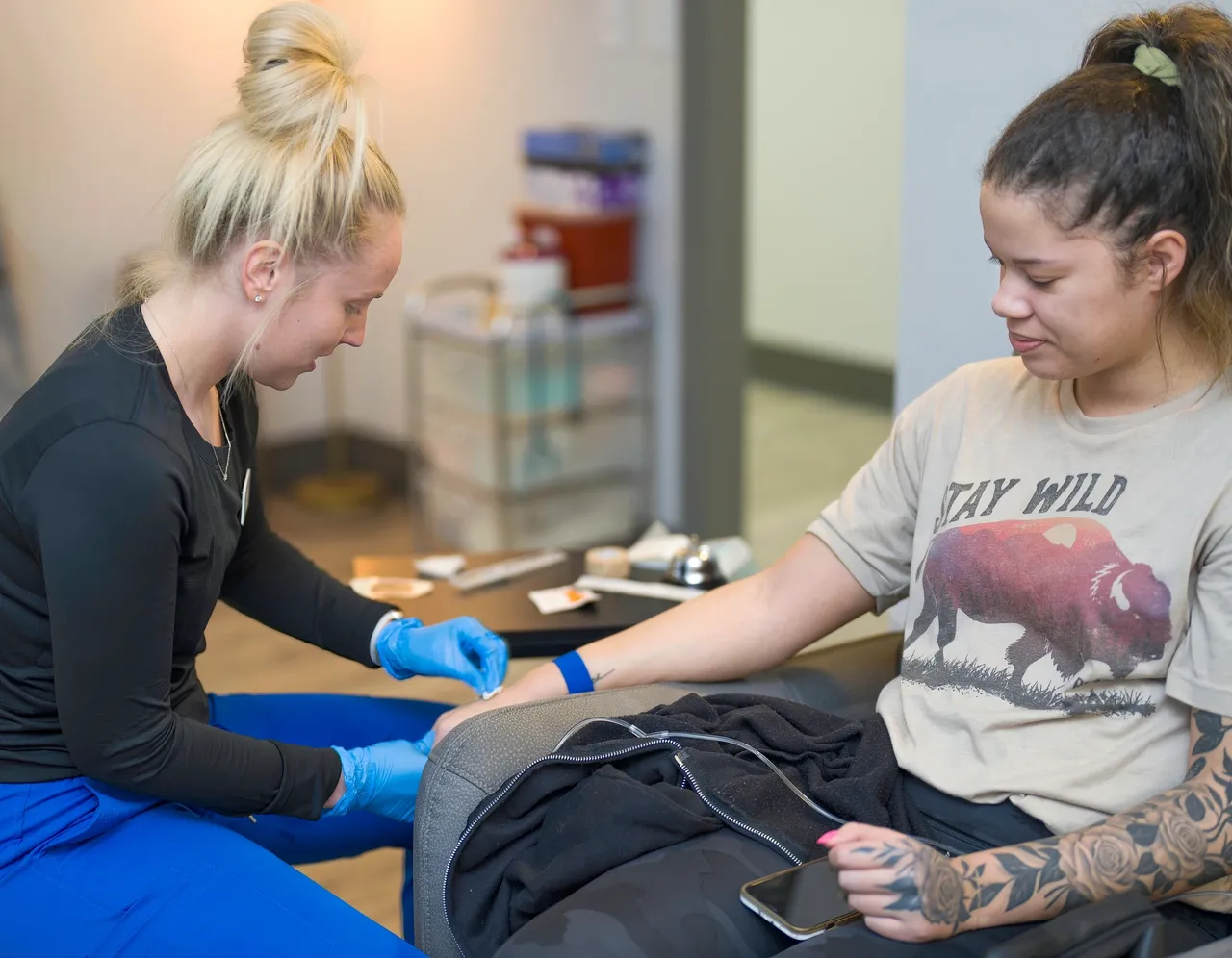 a woman getting a blood sample from a woman - rs=w_1280,h_996