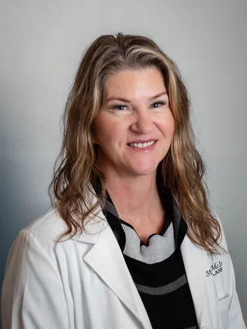 a woman in a white lab coat - stacy mcIntyre
