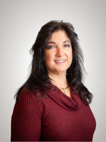 a woman with long dark hair wearing a red sweater - Melinda.webp